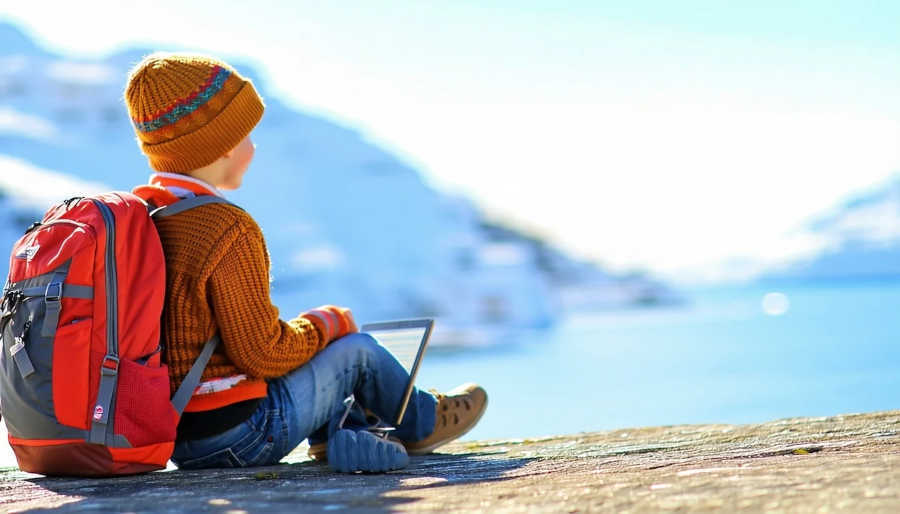Child sitting on a rock, a next generation traveler