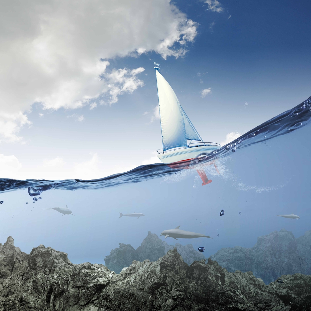Floating yacht and dolphins swimming under water